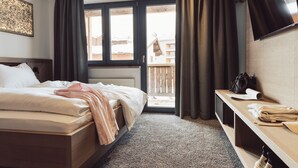 Une chambre d’hôtel avec un lit, un bureau, une télévision et une vue sur l’extérieur.