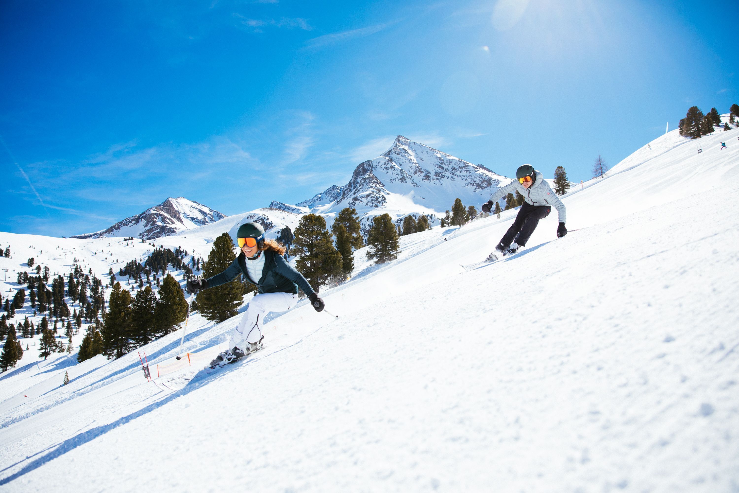 A snowy mountain slope with skiers.
