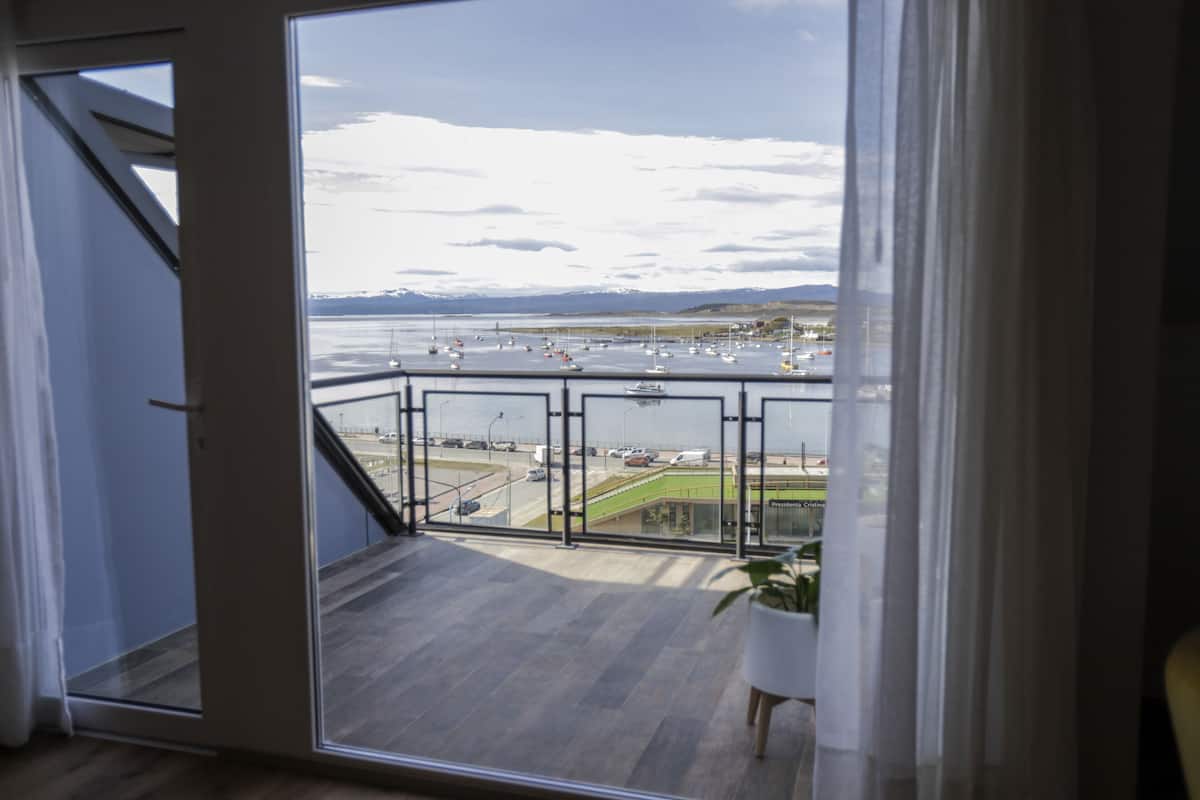 Ein Balkon mit Blick auf eine Marina und ferne Berge.
