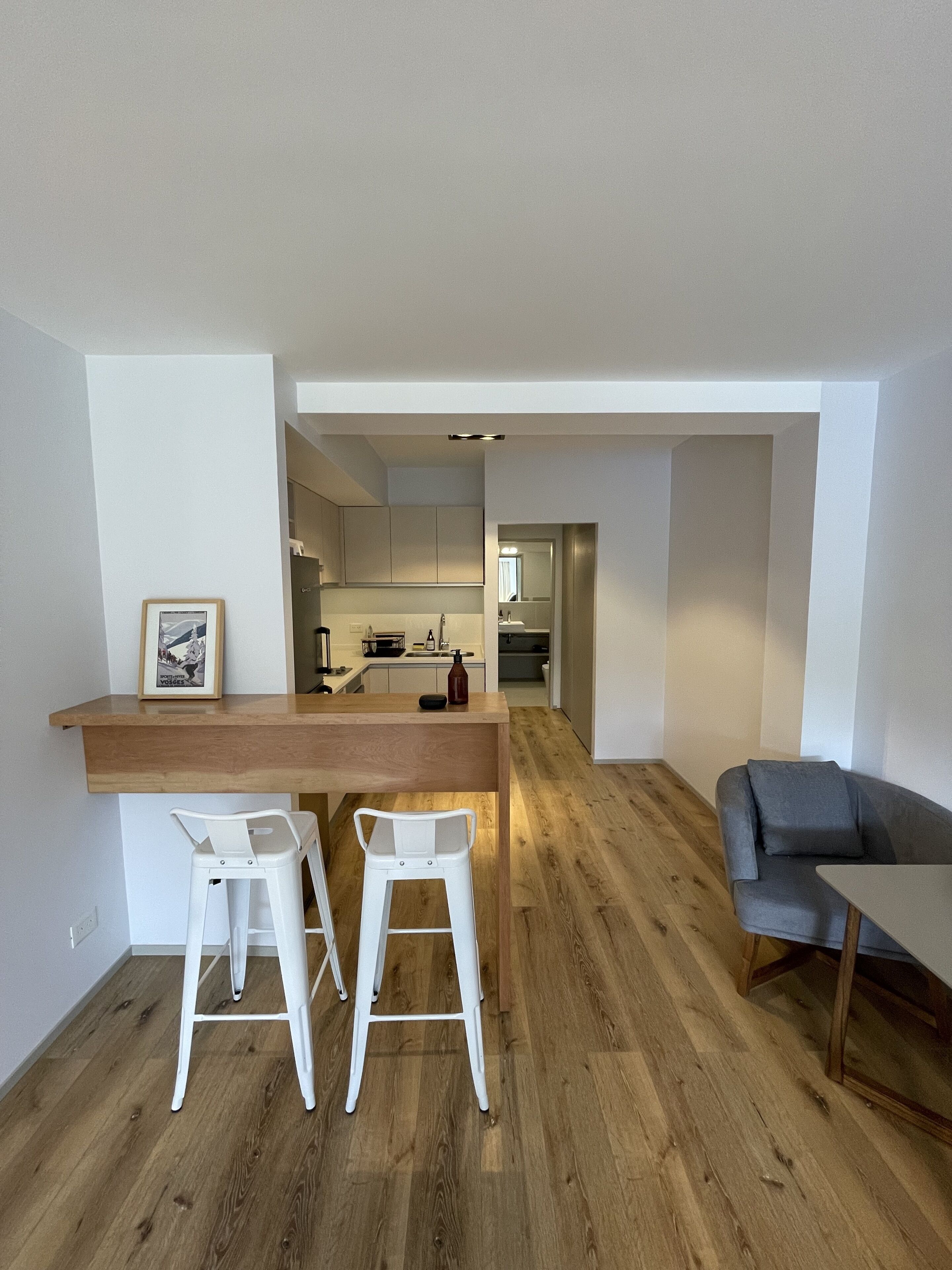 A modern apartment with a kitchen, dining area, and living room.