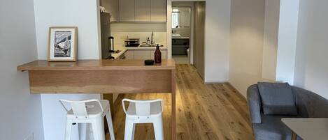 A modern apartment with a kitchen, dining area, and living room.