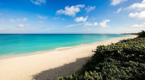 A beach with clear turquoise water and a sandy shore.