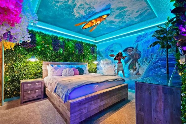 Un dormitorio con cama, mesitas de noche, un mural en la pared y una lámpara en el techo.