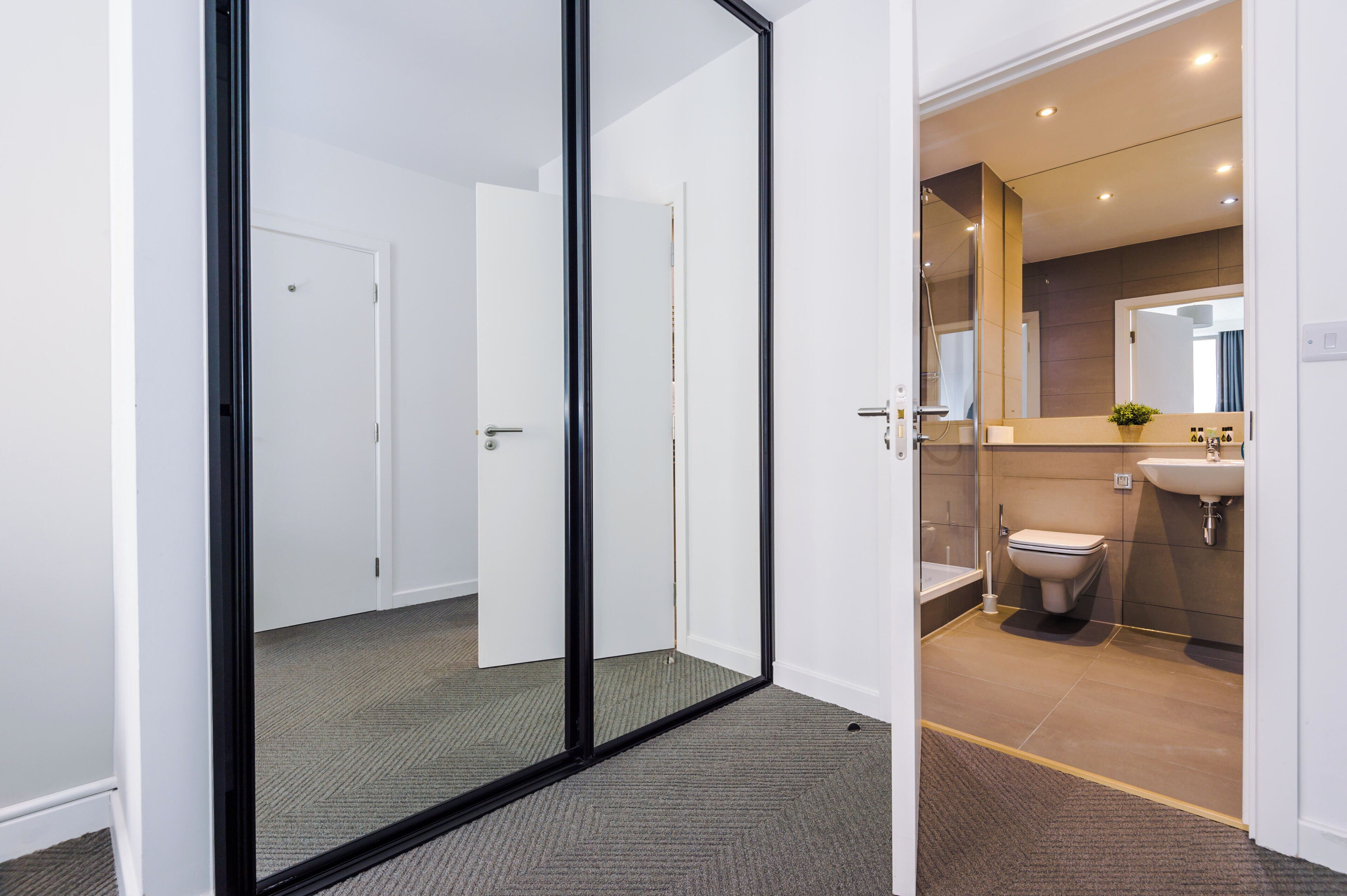 A modern bathroom with a toilet, sink, and shower.