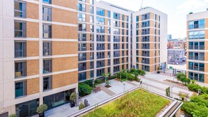 Un edificio moderno de varios pisos con ventanas amplias y un patio interior.