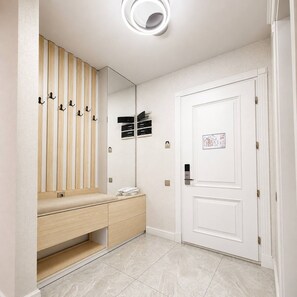 Ein modernes Badezimmer mit einem Holzwaschtisch, einem Spiegel und einer weißen Tür.