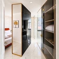 Una habitación de hotel con una cama, un armario y un espejo.