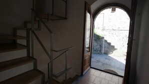 A staircase leading to an outdoor area with a stone wall and a view of a courtyard. - Tuff farmhouse, terrace and garden, pets allowed (Latera)