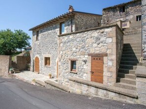 A stone building with a staircase leading to a second floor.