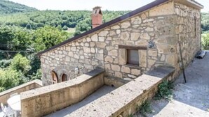 A stone building with a sloped roof, a small window, and a stone staircase leading up to a door. - Tuff farmhouse, terrace and garden, pets allowed (Latera)