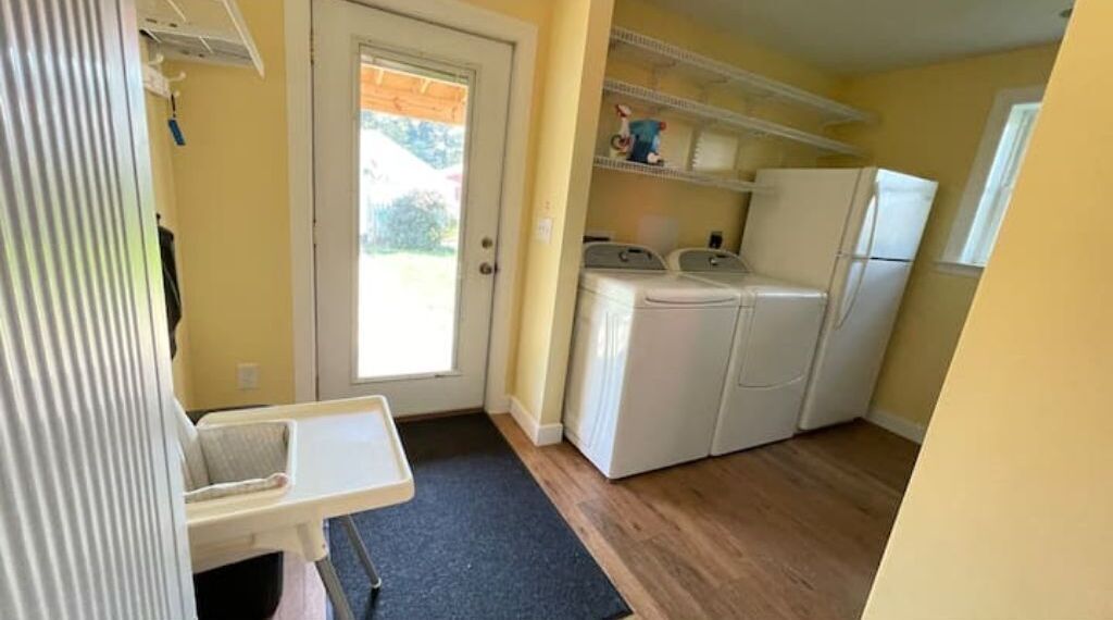 A compact kitchen with a washing machine, a refrigerator, and a small countertop.