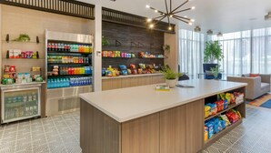 Een moderne receptie met een balie, automaten en een zithoek met uitzicht op de omgeving.