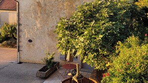A rustic building with a sloped roof, a small circular window, and a chimney. - L'alambic à Martial (Menétru-le-Vignoble)