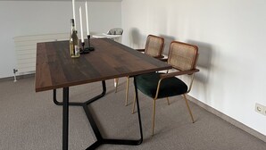 Een vergaderruimte met een lange tafel, twee stoelen, een fles wijn en twee kaarsen.