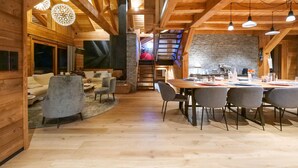 Un interior de madera con comedor, sofás y chimenea.