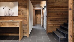 A wooden interior with a reception desk, a framed picture of polar bears, and a staircase.