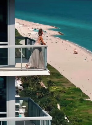 Ein Balkon mit Blick auf Strand und Meer.