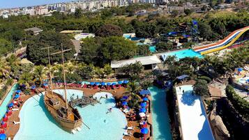 Relax by the pool amidst lush greenery and palm trees, with multiple pools and water slides at your fingertips.