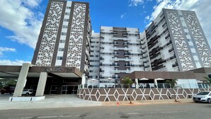 A multi-story hotel with a geometric facade, a covered entrance, and a parking area. - Spazzio diRoma Acqua Park Splash e Slide (Caldas Novas)