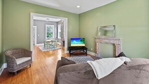 Una sala de estar con un sofá, un televisor y una chimenea.