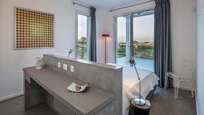 A modern bedroom with a large window, a desk with a lamp, and a chair. - Leucosia - Favignana (Favignana)