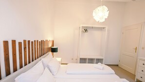 A hotel room with a bed, a wardrobe, a mirror, and a hanging light fixture. - ღSunset I Lakeview Ammersee I BBQ I Liboria I 5min from the lake (Herrsching am Ammersee)