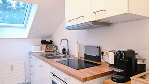 A modern kitchen with white cabinets, a wooden countertop, a built-in oven, a sink, and a window above the sink. - ღSunset I Lakeview Ammersee I BBQ I Liboria I 5min from the lake (Herrsching am Ammersee)