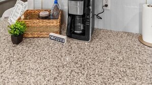 Una cocina con cafetera, una cesta de aperitivos y un cartel que dice 'COFFEE'.