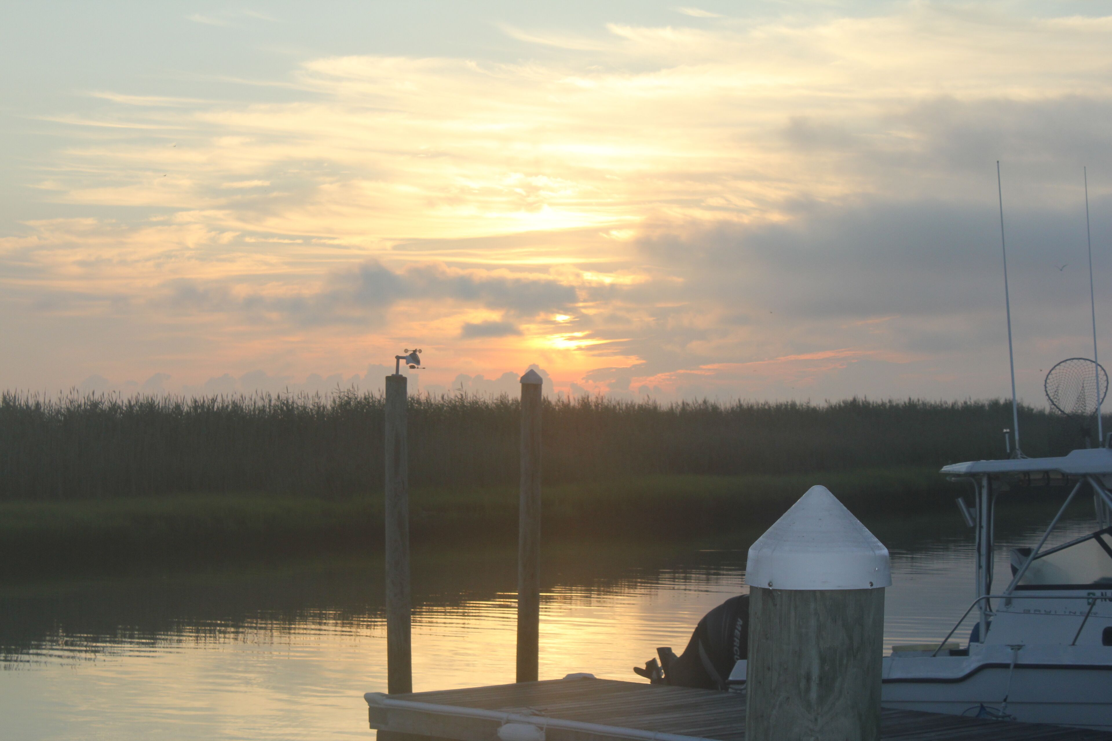 A dock with a boat and a wooden post.