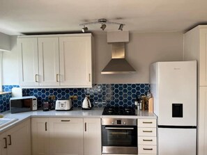Enjoy cooking in this well-equipped kitchen with a gas stove, oven, and ample storage.