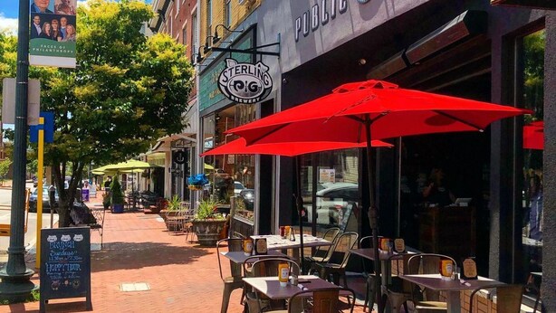 Calle con mesas al aire libre en un restaurante llamado Sterling Brewery.