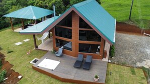 Une maison moderne dotée d’une grande terrasse, d’un patio couvert et d’une piscine.