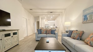 A modern living room with a sofa, a coffee table, and a TV.