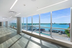 A spacious, modern interior with large windows offering a view of a waterfront and cityscape. - Relaxing Resort Like Stay On The Beach-CS41 (Hollywood)
