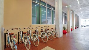 A row of bicycles parked in a covered area with large windows and a concrete floor. - Relaxing Resort Like Stay On The Beach-CS41 (Hollywood)