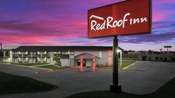 A RedRoof Inn with a large sign, a parking lot, and a building with a flat roof.