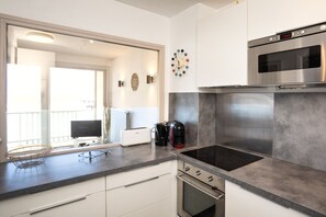 Een moderne keuken met een ingebouwde oven, koffiezetapparaat en broodrooster.