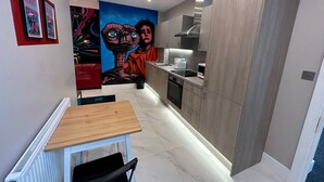 A modern kitchen with wooden cabinets, a built-in oven, and a microwave. - Themed Stunning 1-bed Apartment in London (London)