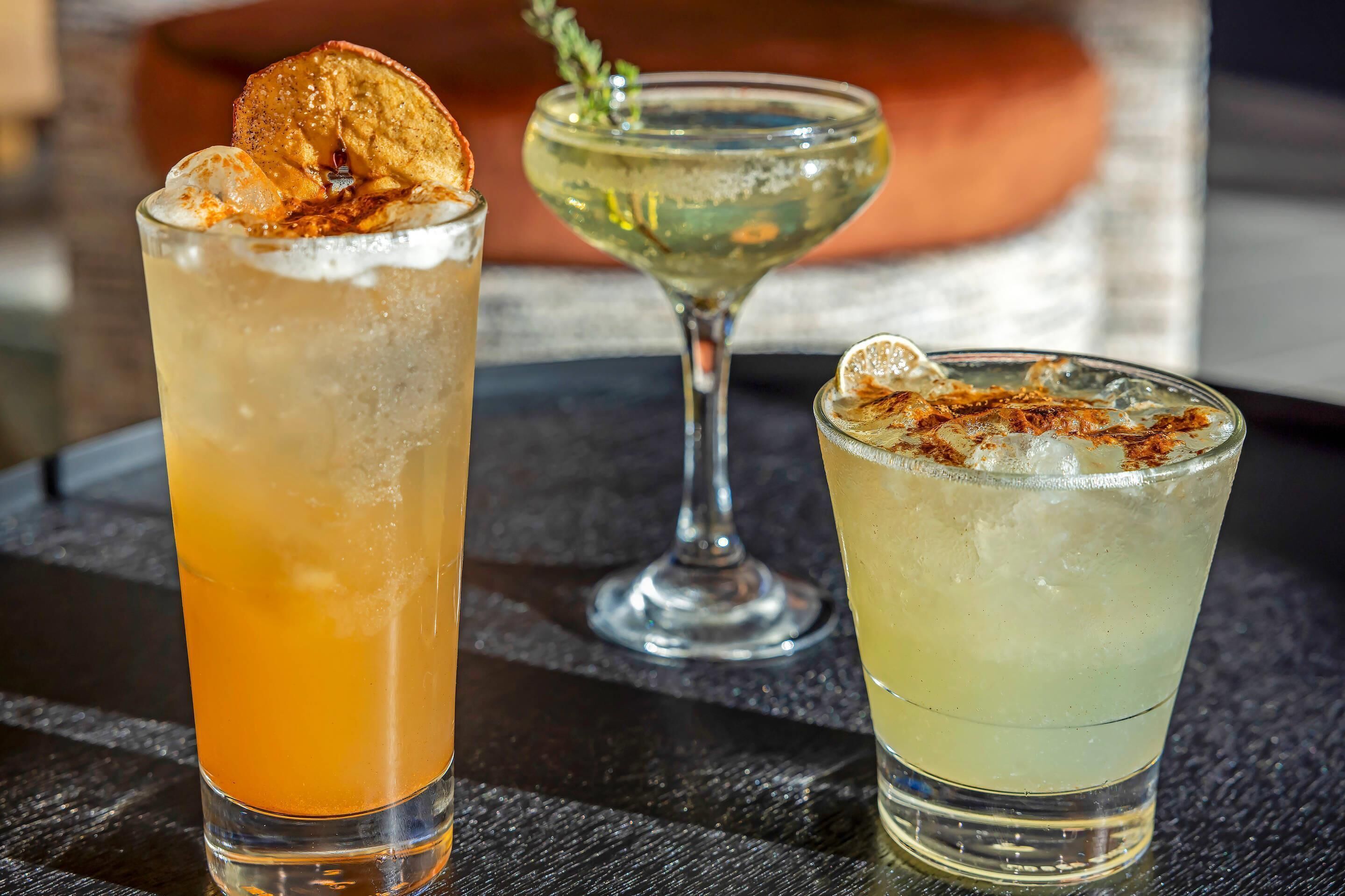 Three glasses of beverages on a table.