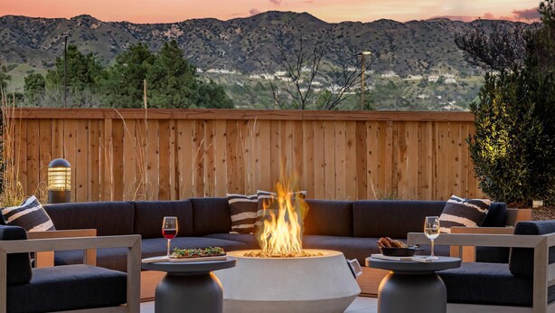 A patio with a fire pit, outdoor seating, and a view of mountains. - Cambria Hotel Burbank Airport (Burbank)