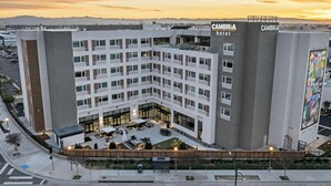 A modern hotel with a courtyard, multiple floors, and a prominent sign. - Cambria Hotel Burbank Airport (Burbank)