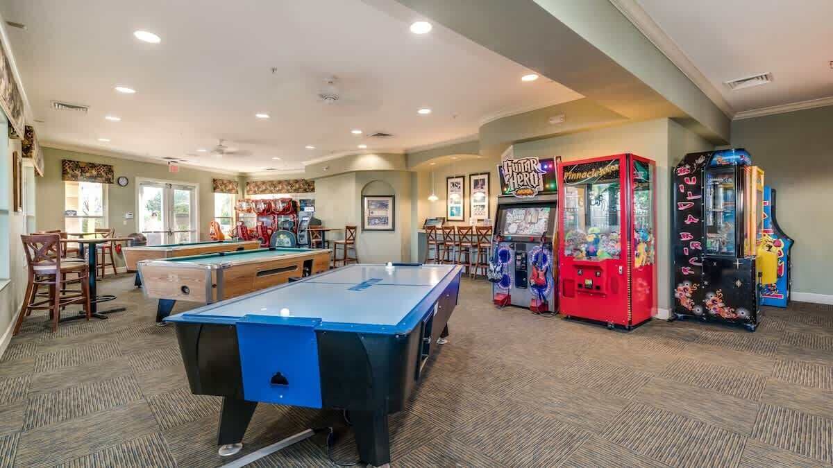 A pool table, arcade games, and a bar area in a hotel room.