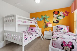 A child's bedroom with bunk beds, a nightstand, and a wall mural.
