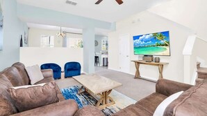 A modern living room with a brown leather sofa, a wooden coffee table, and a television on a stand. - Wonderful Lake View Vacation Getaway (Davenport)