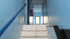 Una escalera con barandillas azules que lleva a una puerta en la parte superior.