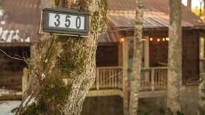 A wooden cabin with a rustic exterior, a porch, and a sign indicating the number 350.