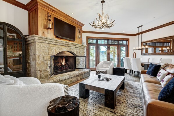 Cozy living area with a stone fireplace, comfortable seating, and a flat-screen TV.