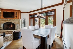 Enjoy meals in this dining area with a large table and six chairs, a stone fireplace, and a flat-screen TV.