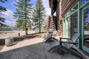 Relax in the serene surroundings of this cozy outdoor patio, complete with Adirondack chairs and a table.