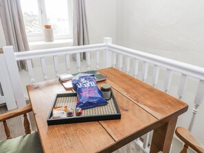 Una mesa de madera con una bandeja que contiene bocadillos, un paquete de sal marina y un tarro de vinagre balsámico.